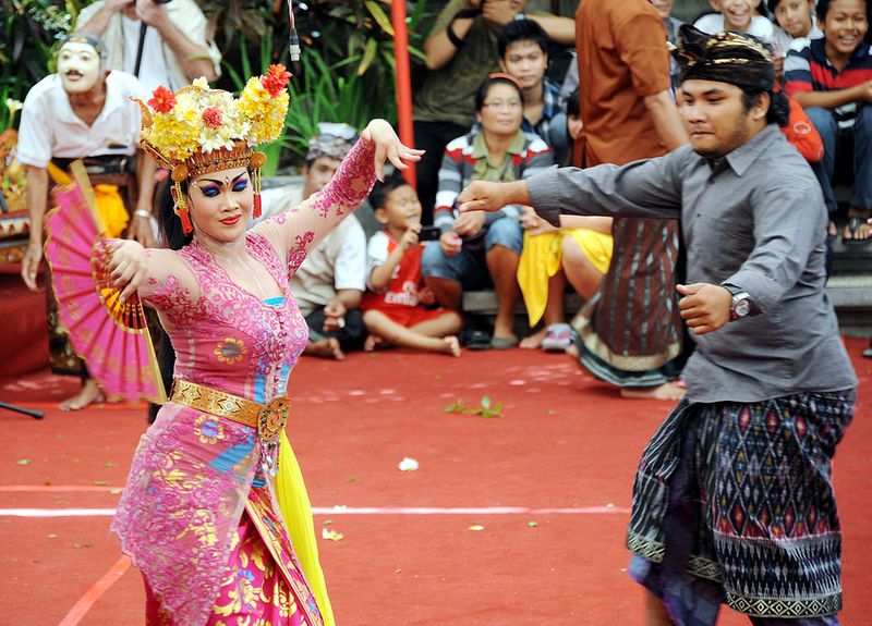A Balinese woman (C) performs a traditional dance of Joget Bumbung during the 35th Bali Art Festival in Denpasar on Indonesia's resort island of Bali on July 4, 2013.  The Joged Bumbung Dance is one of the few exclusively secular dances of Bali, in which the brightly-dressed dancer invites men from the crowd to dance with her in a pretence of seduction.     AFP PHOTO / SONNY TUMBELAKA        (Photo credit should read SONNY TUMBELAKA/AFP via Getty Images)