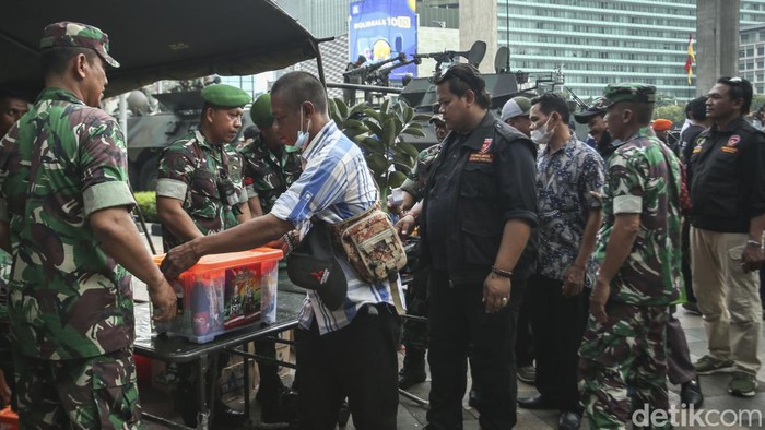 TNI Bagi-bagi Sembako di Bundaran HI Anggota TNI membagikan sembako di sekitar Bundaran HI, Jakarta, Rabu (5/10/2022).