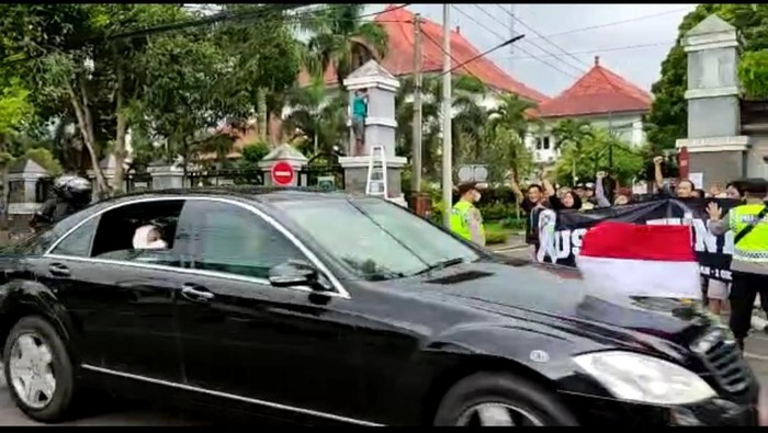 Warga di Malang membentangkan spanduk Usut Tuntas saat Jokowi melintas