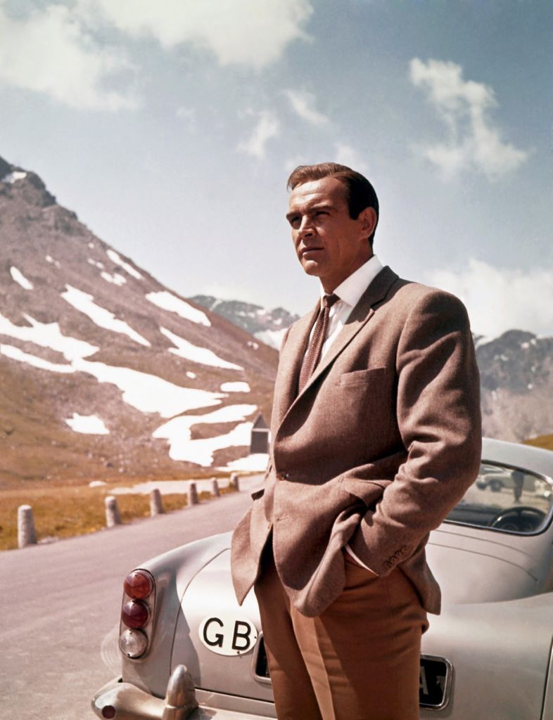 1964:  Actor Sean Connery poses as James Bond next to his Aston Martin DB5 in a scene from the United Artists film 'Goldfinger' in 1964 (Photo by Donaldson Collection/Michael Ochs Archives/Getty Images)