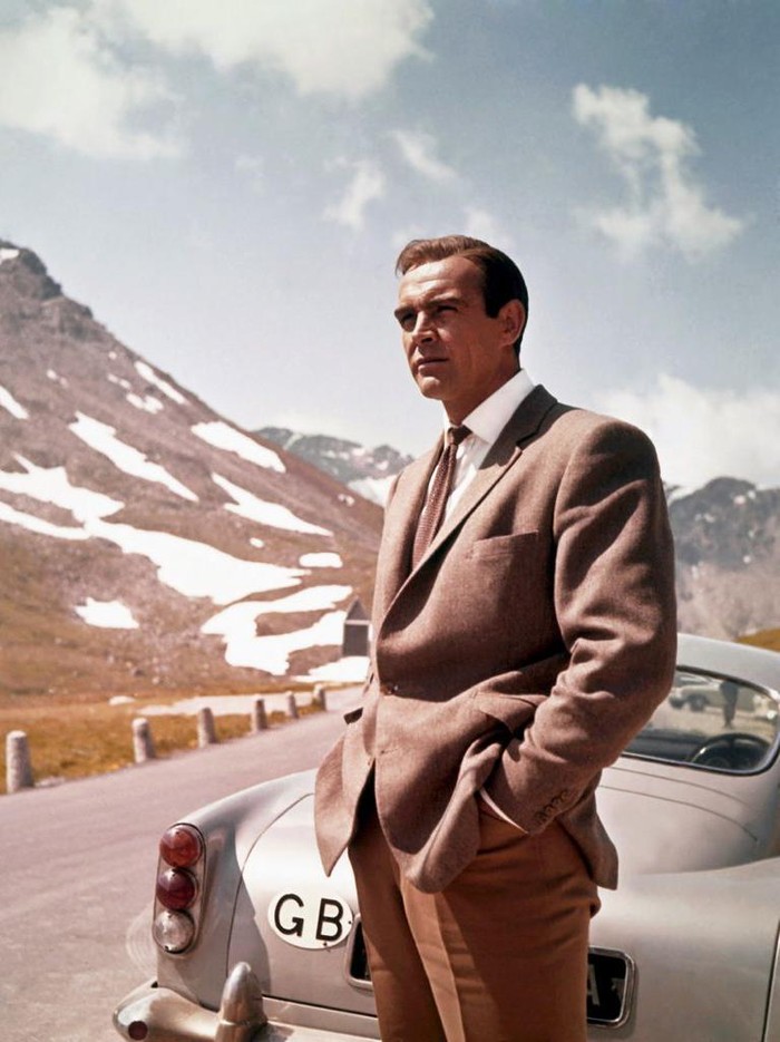 1964:  Actor Sean Connery poses as James Bond next to his Aston Martin DB5 in a scene from the United Artists film 'Goldfinger' in 1964 (Photo by Donaldson Collection/Michael Ochs Archives/Getty Images)