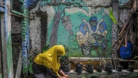 Warga merawat tanaman pakcoy yang ditanam di lahan sempit. Warga tersebut memanfaatkan lahan sempit di permukiman menjadi lahan pertanian yang dilakukan secara swadaya.