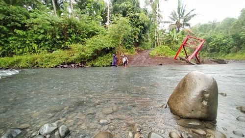 Aktivitas warga melintasi sungai karena jembatan putus di Banjar Nusamara, Desa Yehembang Kangin, Mendoyo, Jembrana, Kamis (6/10/2022)