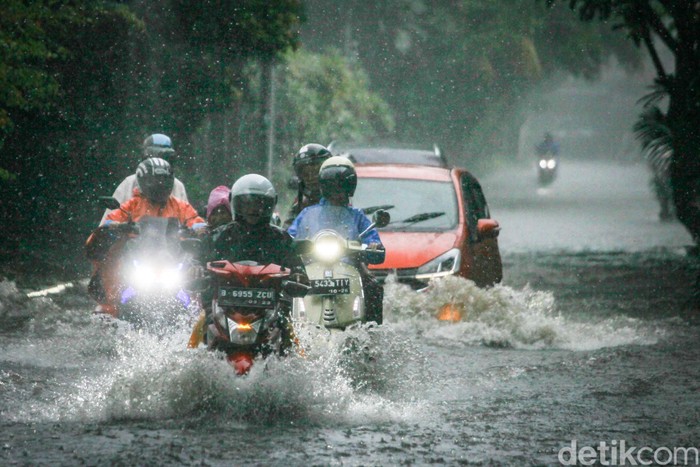 Hujan deras membuat Jalan Cinere Raya, Depok, tergenang. Kendaraan pun berhati-hati agar tidak mogok.