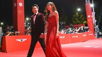 Mikha Tambayong tampak bergaun merah rancangan Jeffry Tan sementara Deva Mahenra mengenakan setelan jas berwarna gelap rancangan Rusli Hadiwinata. (Foto: dok. Disney+ Hotstar)