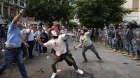 Para pengunjuk rasa melemparkan botol-botol ke gedung Bank Sentral Lebanon, tempat para demonstran anti-pemerintah berunjuk rasa. AP/Hassan Ammar