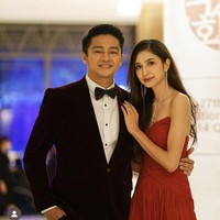 Deva Mahendra tampil memakai setelan jas velvet berwarna burgundy karya desainer Rusli Hadiwinata. Sedangkan Mikha Tambayong memakai gaun berekor panjang ‘hand pleated chiffon silk in crimson red’ rancangan desainer Jeffrey Tan. Foto: Instagram