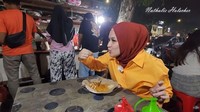 Nathalie juga hobi jajan kaki lima. Salah satu momennya ketika menikmati sate taichan di pinggir jalan. Foto: Instagram & YouTube Nathalie Holscher