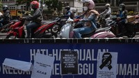 Sepeda motor melewati plakat bertuliskan Selidiki dengan seksama menyusul kerusuhan dan penyerbuan setelah pertandingan sepak bola antara Arema FC dan Persebaya. Getty Images/Ulet Ifansasti