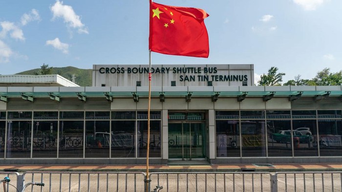 Bendera Tiongkok berkibar di depan Bus Antar-Jemput Lintas Perbatasan San Tin Terminus, Lok Ma Chau, Hong Kong China, Rabu (5/10/2022).