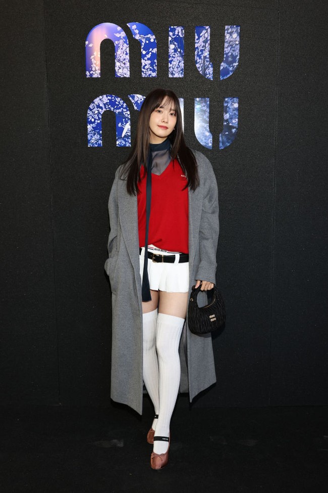 Yoona hadir memakai koleksi coat panjang Miu Miu berwarna abu-abu, yang dipadukan dengan atasan senada dan sweater merah. Lengkap dengan low-waisted skirt khas brand asal Italia tersebut. Foto: dok. Getty Images