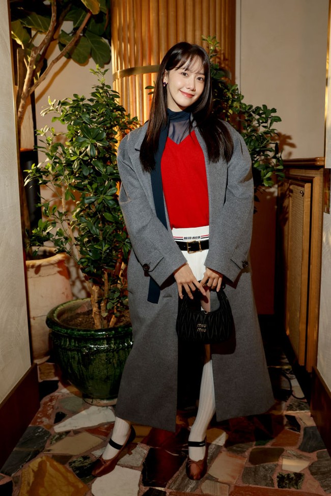 Penampilan Yoona semakin lengkap dengan koleksi heels Miu Miu berwarna coklat dan kaos kaki putih panjang. Yoona juga memakai koleksi tas Miu Wander matelassé nappa leather mini hobo bag seharga $2,300 atau sekitar Rp 34 jutaan. Foto: dok. Getty Images