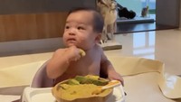 Baby Izz tampak lahap menikmati irisan alpukat dengan flaxseed dan pendamping puree ubi. Meal time with ibu & papa, kata Nikita Willy.