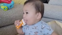 Camilan Baby Izz tak kalah enak dan sehat lho! Ia makan es loli yang terbuat dari pisang, stroberi, dan yogurt kelapa. 
