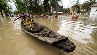 Warga berusaha melintasi banjir menggunakan perahu di Lhoksukon, Aceh Utara, Aceh, Kamis (6/10/2022). Sebelumnya, banjir di Aceh Utara terjadi akibat meluapnya sungai setelah daerah itu diguyur hujan lebat. Sejumlah sungai meluap antara lain Krueng Keureutou, sungai Krueng Pase, sungai Krueng Peuto, dan sungai Krueng Pirak. (ANTARA FOTO/Rahmad)