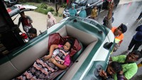 Sejumlah personel Brimob bersama warga menurunkan seorang pasien dari truk saat dievakuasi dari kawasan terisolir banjir di Desa Meunasah Blang, Aceh Utara, Aceh, Kamis (6/10/2022). Petugas gabungan masih mendata korban terdampak banjir. (ANTARA FOTO/Rahmad)