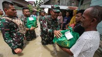 Dandim 0103 Aceh Utara Letkol Inf Hendrasari Nurhono (tengah) menyerahkan bantuan sembako kepada warga terdampak banjir di Lhoksukon, Aceh Utara, Aceh, Kamis (6/10/2022). Berdasarkan data dari Camat Lhoksukon, jumlah sementara pengungsi di kecamatan tersebut berjumlah 31.404 orang. Pihak pemerintah mulai menyalurkan bantuan ke pengungsi. (ANTARA FOTO/Rahmad)