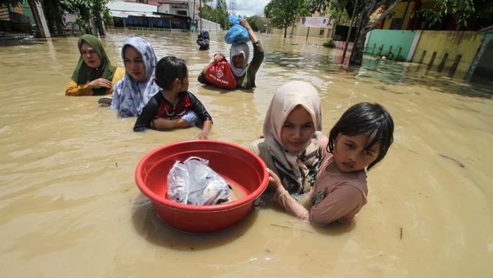Aceh Utara Terendam Banjir, 31 Ribu Warga Mengungsi Sejumlah bertusaha melintasi banjir di Lhoksukon, Aceh Utara, Aceh Kamis (6/10/2022). Badan Penanggulangan Bencana Aceh (BPBA) menyebutkan banjir akibat hujan deras dalam dua hari terakhir tersebut merendam 12 kecamatan di Aceh Utara serta 35 ribu warga mengungsi, dan pemerintah setempat menetapkan status darurat banjir selama 14 hari kedepan. ANTARA FOTO/Rahmad/YU