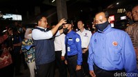 Anies memakaikan peci kepada sopir Mikrotrans AC.