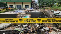 Sampah dan puing-puing tembok belum dibersihkan.