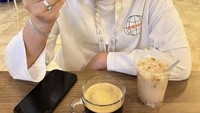 Pelantun lagi Satru ini juga doyan ngopi. Begini gayanya saat minum kopi hitam dan salah fokus dengan es doger di sebelahnya. Foto: Instagram @happy_asmara77