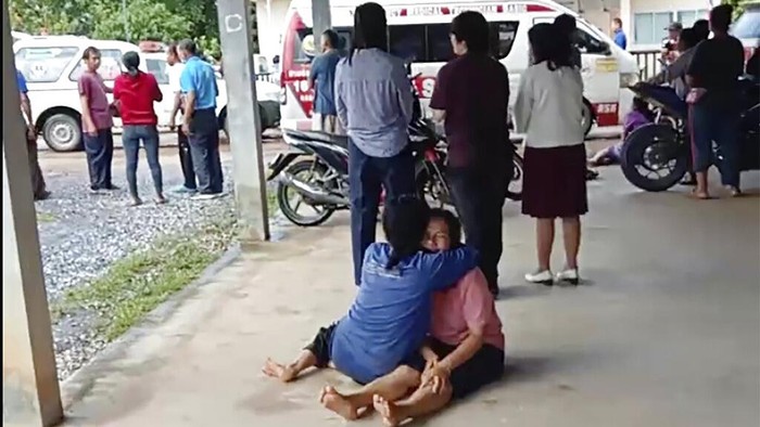 Seorang wanita menghibur orang tua yang anaknya menjadi korban di pusat penitipan anak, Nongbua Lamphu, Thailand, Kamis (6/10/2022). (Mungkorn Sriboonreung Rescue Group via AP)