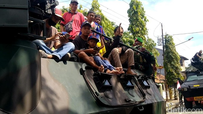 Warga Kota Pekalongan naik kendaraan taktis TNI saat Kirab HUT TNI, Jumat (7/20/2022).