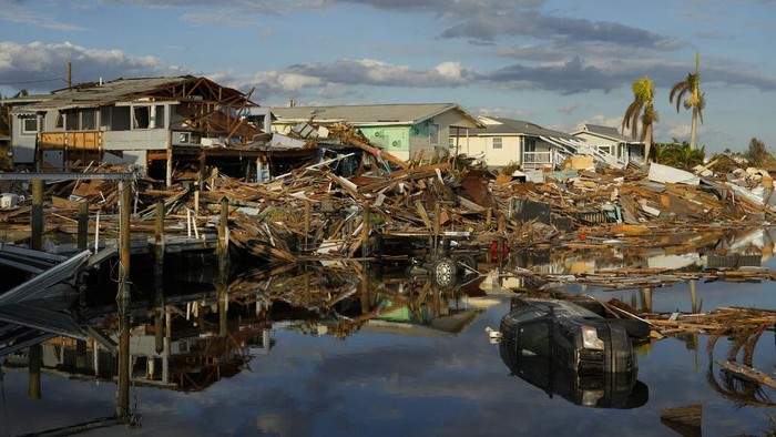 Kota Pesisir Pantai di Florida Porak Poranda Dihantam Badai Ian Snowbird Bruce Hickey, 70, walks along the waterfront, now littered with debris including shrimp boats, in the mobile home park where he and his wife Kathy have a winter home, a trailer originally purchased by Kathy's mother in 1979, on San Carlos Island, Fort Myers Beach, Fla., Wednesday, Oct. 5, 2022, one week after the passage of Hurricane Ian. (AP Photo/Rebecca Blackwell)