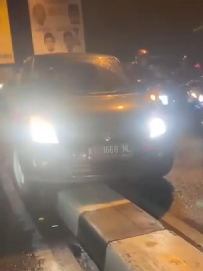 Mobil nyangkut di pembatas jalan di Depok (tangkapan layar)