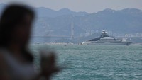 Seorang wanita berdiri di sebelah Yacht Nord milik Oligarki Rusia Alexei Mordashov yang terlihat berlabuh di Hong Kong. Mordashov adalah salah satu miliarder terkaya Rusia, dengan kekayaan diperkirakan lebih dari 18 miliar dolar AS menurut perkiraan Bloomberg.