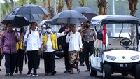 Dengan memakai payung, Jokowi berkeliling meninjau Taman Hutan Raya Ngurah Rai.