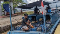 Pengisian ini mereka lakukan dengan perahu tradisional berbahan bakar solar.