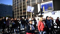 Seorang pengunjuk rasa memegang spanduk menyerukan pemogokan selama demonstrasi yang diselenggarakan oleh pekerja penitipan anak di Paris. Sekitar 50 asosiasi dan serikat pekerja bergabung dalam aksi mogok kerja dan demo di Paris tersebut. 