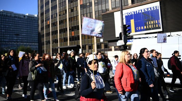 Protesters carry a banner reading 'No baby in the locker' during a demonstration organised by daycare workers in Paris on October 6, 2022. (Photo by Christophe ARCHAMBAULT / AFP) (Photo by CHRISTOPHE ARCHAMBAULT/AFP via Getty Images)