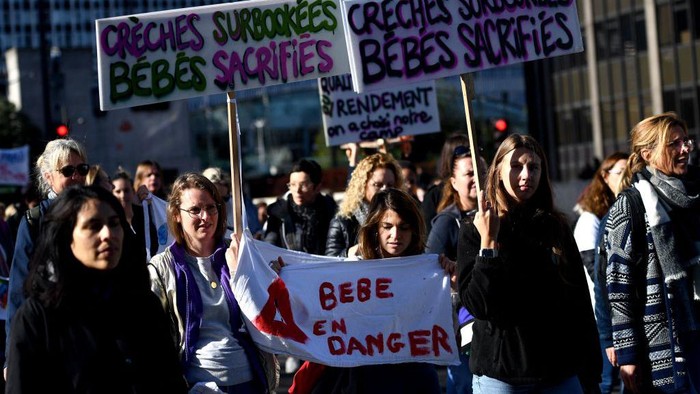 Ribuan Pengasuh Bayi di Prancis Demo Tuntut Kenaikan Upah Protesters carry a banner reading 'No baby in the locker' during a demonstration organised by daycare workers in Paris on October 6, 2022. (Photo by Christophe ARCHAMBAULT / AFP) (Photo by CHRISTOPHE ARCHAMBAULT/AFP via Getty Images)
