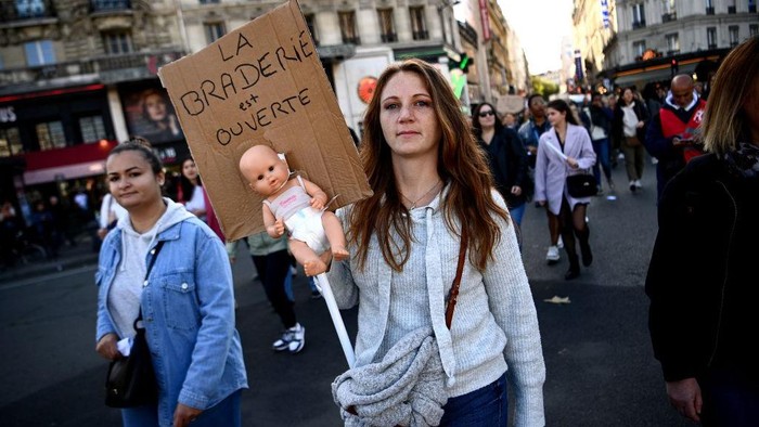 Ribuan Pengasuh Bayi di Prancis Demo Tuntut Kenaikan Upah Protesters carry a banner reading 'No baby in the locker' during a demonstration organised by daycare workers in Paris on October 6, 2022. (Photo by Christophe ARCHAMBAULT / AFP) (Photo by CHRISTOPHE ARCHAMBAULT/AFP via Getty Images)