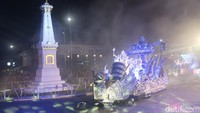 Tampak pula dua unit kendaraan bermotor yang dihias dengan tari kolosal mengiringi iring-iringan tersebut. Sesampainya di sisi selatan Tugu Pal Putih, orang-orang tersebut menampil koreografi yang gerakannya menyesuaikan musik. Foto: Pradito Rida Pertana/detikJateng