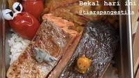 Tipang begitu panggilan akrabnya, sering membuatkan sang suami bekal makan siang. Bekalnya bernutrisi tinggi karena menggunakan ikan salmon yang digoreng dengan sedikit minyak, ada juga bakwan jagung dan nasi putih. Foto: Instagram @tiarapangestika