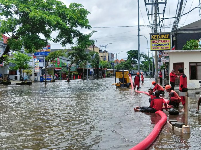 Dinas PUPR Badung  terlihat sibuk melakukan penyedotan air di Jalan Dewi Sri, Kuta, Badung, Bali, Sabtu (8/10/2022).