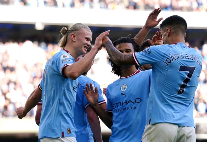 Manchester Citys Erling Haaland (left) celebrates with team-mate Joao Cancelo after scoring their sides fourth goal of the game during the Premier League match at Etihad Stadium, Manchester. Picture date: Saturday October 8, 2022. (Photo by Martin Rickett/PA Images via Getty Images)
