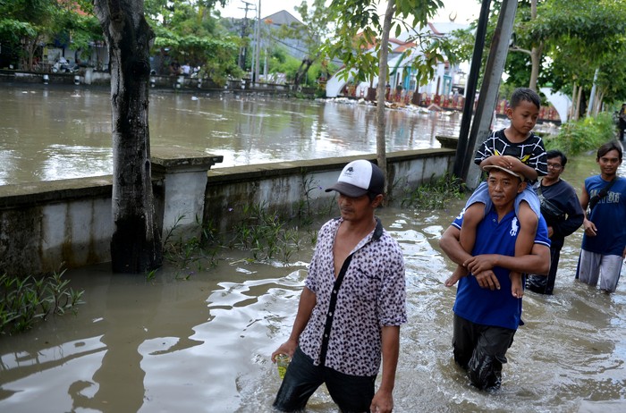 Warga berjalan menerobos banjir yang menggenangi kawasan Legian, Badung, Bali, Sabtu (8/10/2022). Hujan yang mengguyur Bali sejak Jumat (7/10) mengakibatkan banjir di berbagai titik di wilayah Kota Denpasar dan Kabupaten Badung Bali dengan ketinggian genangan air yang bervariasi. ANTARA FOTO/Fikri Yusuf/hp.