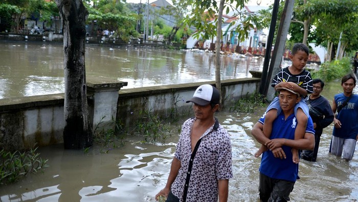 Melihat Banjir di Bali Gegara Hujan Hari Jumat Warga berjalan menerobos banjir yang menggenangi kawasan Legian, Badung, Bali, Sabtu (8/10/2022). Hujan yang mengguyur Bali sejak Jumat (7/10) mengakibatkan banjir di berbagai titik di wilayah Kota Denpasar dan Kabupaten Badung Bali dengan ketinggian genangan air yang bervariasi. ANTARA FOTO/Fikri Yusuf/hp.