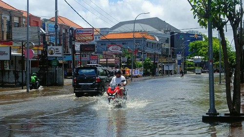 Pantauan detikBali hingga Sabtu (8/10/2022) siang sekitar pukul 12.30 Wita, banjir di Jalan Dewi Sri, Kuta, Badung, Bali, belum surut. Pengendara motor dan mobil tampak menerobos air yang masih menggenang.