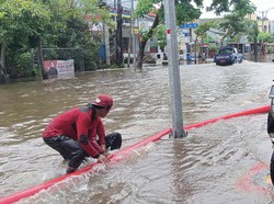 Pengendara motor bule tampak berusaha menerobos banjir di Jalan Dewi Sri Kuta. Foto: Triwidiyanti/detikBali