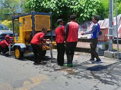 Petugas PUPR Badung melakukan penyedotan air di Jalan Kresna, Legian, Kuta. Foto: Triwidiyanti/detikBali