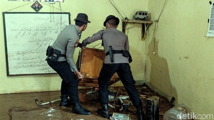Polisi saat membantu korban banjir di Sukabumi