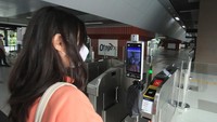 Seorang calon penumpang mencoba alat pendeteksi wajah yang juga berfungsi sebagai tiket di stasiun MRT Asean, Jakarta, Sabtu (8/10/2022).