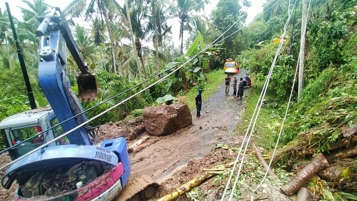Longsoran tanah yang menutup jalan dikeruk menggunakan alat berat di Desa Yehembang Kangin, Mendoyo, Jembrana, Bali Sabtu (8/10/2022).