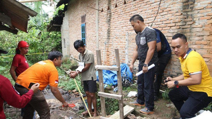 Tersangka Erwinudin memperagakan adegan dalam rekonstruksi kasus pembunuhan 4 keluarganya yang jasadnya dibuang ke dalam Septic Tank di Desa Marga Jaya, Kecamatan Negera Batin, Kabupaten Way Kanan, Lampung,  Jumat (8/10/2022). Foto: Tommy Saputra/detikSumut