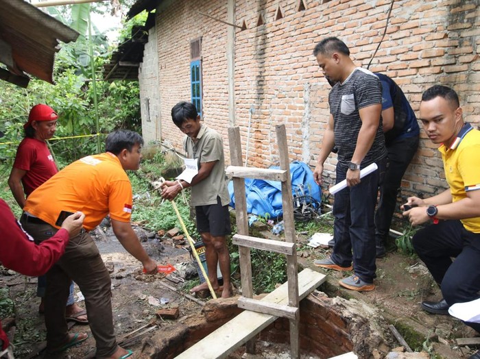 Way Kanan Tersangka Erwinudin memperagakan adegan dalam rekonstruksi kasus pembunuhan 4 keluarganya yang jasadnya dibuang ke dalam Septic Tank di Desa Marga Jaya, Kecamatan Negera Batin, Kabupaten Way Kanan, Lampung, Jum'at (8/10/2022). Foto: Tommy Saputra/detikSumut